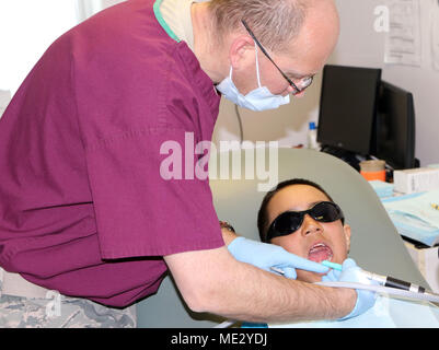 Le lieutenant-colonel Gregory Schmidt, un dentiste affecté à la 122e Escadre de chasse de la Garde nationale aérienne de l'Indiana, nettoie les dents d'un jeune patient, le 17 avril, à l'appui des soins de l'Arctique en 2018, à la Clinique de Kivalina, Kivalina, en Alaska. Soins de l'Arctique en 2018 et d'autres exercices de préparation novatrices démontrer l'efficacité clinique et de la capacité logistique de l'armée américaine tout en fournissant des soins médicaux pour les régions mal desservies des États-Unis. (U.S. Photo de l'Armée de l'air par le Major Joe Simms) Banque D'Images