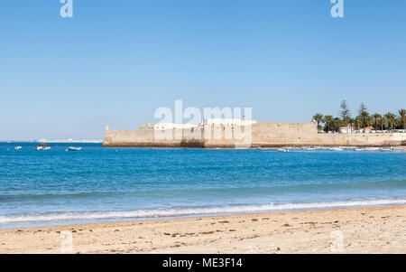 La vue sur la plage de la Caleta en direction du château de Santa Catalina à Cadix, Espagne. Banque D'Images