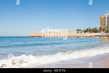 La vue sur la plage de la Caleta en direction du château de Santa Catalina à Cadix, Espagne. Banque D'Images