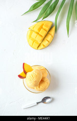 Glace ou d'un sorbet de mangue dans un bol. La crème glacée mangue fruits maison sur fond blanc, copie de l'espace. Banque D'Images