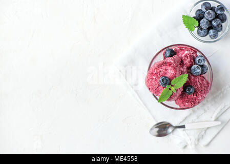 Maison saine et banane végétalien premières berry ice cream (crème glacée, nicecream) surmontées de bleuets biologiques et menthe - régime végétarien sain vegan r Banque D'Images