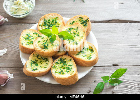 Pain grillé à l'ail et fines herbes avec des ingrédients sur fond de bois, copie de l'espace. Banque D'Images