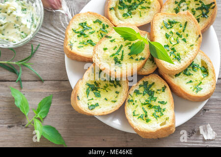Pain grillé à l'ail et fines herbes avec des ingrédients sur fond de bois, copie de l'espace. Banque D'Images