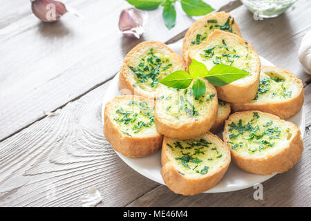 Pain grillé à l'ail et fines herbes avec des ingrédients sur fond de bois, copie de l'espace. Banque D'Images