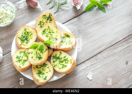 Pain grillé à l'ail et fines herbes avec des ingrédients sur fond de bois, copie de l'espace. Banque D'Images