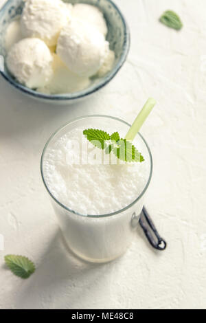 Agiter avec de la glace vanille et menthe sur fond blanc. Glace vanille Milk Shake. Smoothie banane avec la menthe et la vanille. Banque D'Images