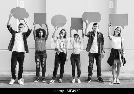 Young adult friends holding up copyspace placard bulles Banque D'Images