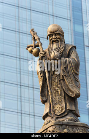 Décoration Sculpture sur Daci temple bouddhiste toit contre un bâtiment moderne dans Chengdu, Chine Banque D'Images