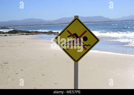 Pas de piscine sign post at beach en Australie. "Pas de piscine jaune' sur le sable avec vue sur la mer et les rochers en arrière-plan. Endroit dangereux de nager. Banque D'Images