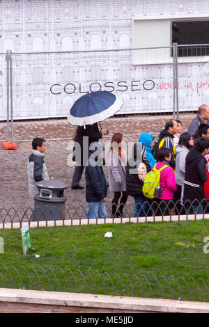 Rome, Italie - 22 Février 2015 : dans une rue à côté du Colisée à pied les touristes faisant la queue pour entrer dans le site. Un homme hods un parapluie sous la pluie. Banque D'Images