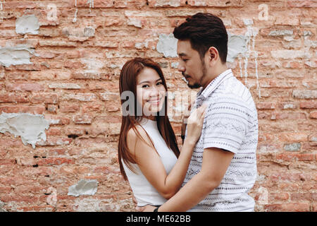 Joli couple asiatique par un mur de briques Banque D'Images