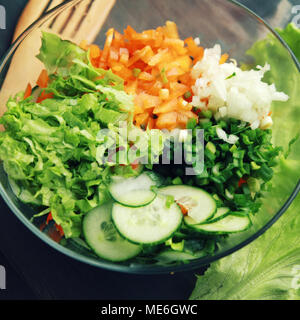 Bol en verre avec couper les légumes pour une salade. Vue d'en haut. Close up. Le poivron, l'oignon, les légumes verts et le concombre coupé en morceaux. Plat végétarien. Banque D'Images