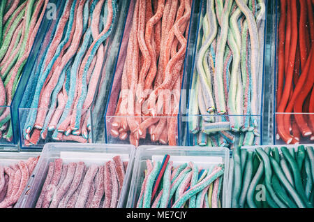 Délicieux bonbons réglisse multicolore dans des contenants en plastique. Délice sucré. Dans la boutique de confiseries. Scène de la gourmandise. Les couleurs sont éclatantes. Filtre bleu photo Banque D'Images