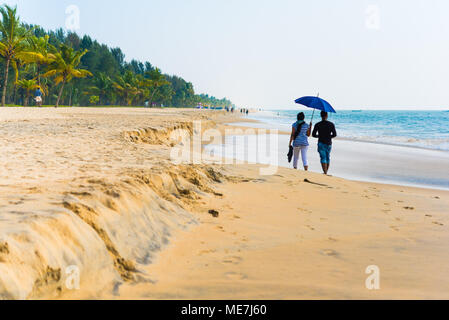 Couple (non identifiés) sous égide marche sur Marari Beach à Mararikulam, Inde en décembre. La plage est considéré comme le meilleur dans le district d'Alleppey Banque D'Images