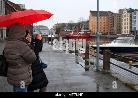 Les femmes prises de photos avec parapluie en Guest Harbour Pier au nord de Katajanokka, Helsinki, Finlande. Banque D'Images