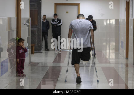 Al-Daly cycliste palestinienne Alaa, 21 ans, qui a perdu sa jambe par une balle tirée par des soldats israéliens lors d'affrontements le long de la frontière entre Israël et Gaza, marche avec des béquilles dans un hôpital de la ville de Gaza, 18 avril 2018. Al-Daly sa blessure le 30 mars 2018 a terminé son rêve de concurrencer dans les Jeux Asiatiques et des vagues le drapeau palestinien à Jakarta, cependant il est prêt à livrer concurrence à l'avenir d'une personne amputée. Photo : Wissam Nassar/dpa Banque D'Images