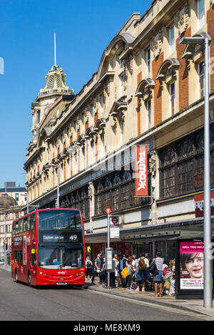 Un rouge à 49 London bus un arrêt de bus devant l'ancien Arding et Hobbs department store building à Clapham Junction dans le sud de Londres. Banque D'Images