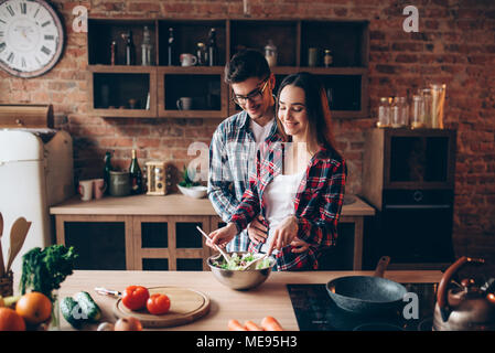 Amour couple cooking sur la cuisine, une salade de légumes préparation. Alimentation nourriture frais. L'homme et de la femme prépare le dîner romantique Banque D'Images