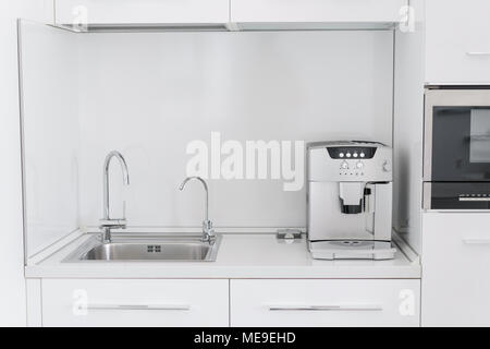 Metal chrome lavabo avec deux robinets, lisse et de l'eau filtrée. Fragment d'une cuisine moderne avec comptoir et évier. Détail de l'intérieur Banque D'Images