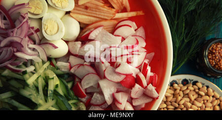 Ingrédients pour une salade d'œufs de caille sur la plaque ronde. Close up.Une cuisine européenne. Des œufs, des radis, des tranches de concombre et les pignons de pin. Vue d'en haut. Wifi colorés Banque D'Images