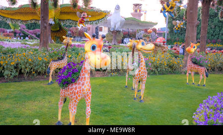 Les Girafes bébé dans un jardin de fleurs colorées Banque D'Images