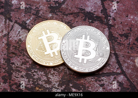 Silver et golden bitcoins sur fond rouge, Close up. Banque D'Images