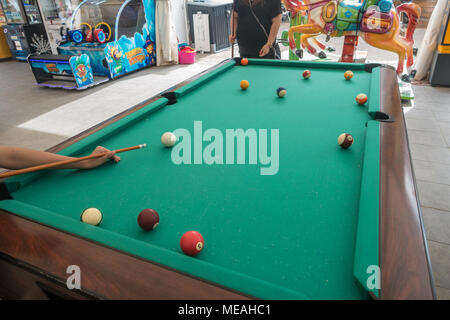 Un joueur aligne un tir sur une table de billard. Banque D'Images