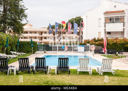 Piscine et transats vides lors d'un froid, temps couvert, terne, Vilamoura, Algarve, Portugal. Banque D'Images