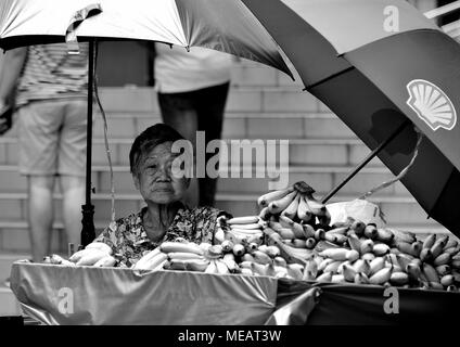 Singapour - 13 Avril 2018 : personnes âgées femme chinoise la vente de bananes à son décrochage routière dans Chinatown, Singapour Banque D'Images