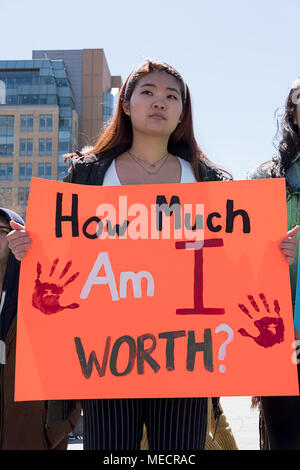 Une jeune fille asiatique avec un signe demandant Quel suis-je d'une valeur à la grève des écoles nationales rassemblement à Washington Square Park, à New York. Banque D'Images