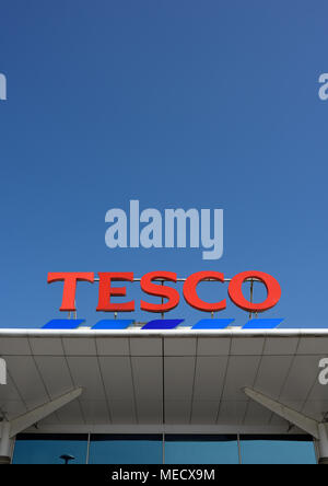 Le logo du supermarché Tesco est monté sur le panneau de toit blanc du magasin tesco au soleil éclatant et dans un ciel bleu clair sans nuages dans le lancashire de bury Banque D'Images