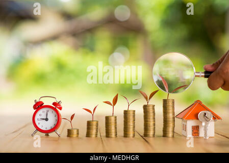 Chambre placés sur les pièces de monnaie dans la main des hommes est l'épargne de l'argent planification de pièces de monnaie pour acheter une maison concept concept pour l'accession à la propriété, des prêts hypothécaires et l'immobilier investir Banque D'Images