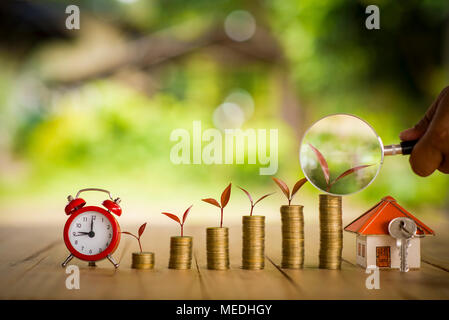 Chambre placés sur les pièces de monnaie dans la main des hommes est l'épargne de l'argent planification de pièces de monnaie pour acheter une maison concept concept pour l'accession à la propriété, des prêts hypothécaires et l'immobilier investir Banque D'Images