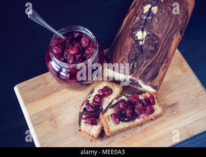 En gâteau au chocolat accompagné de remplissage avec sweet cherry en tête au sirop. Banque D'Images