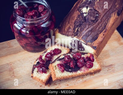 En gâteau au chocolat accompagné de remplissage avec sweet cherry en tête au sirop. Banque D'Images