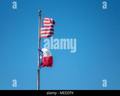 Voir l'USA et le Texas Drapeaux contre le vent avec un ciel bleu Banque D'Images