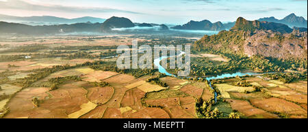 Aerial oiseau, heure du lever vue sur Paysage avec vallée de la Rivière, montagnes karstiques et les rizières. Le Laos, Vang Vieng. Banque D'Images