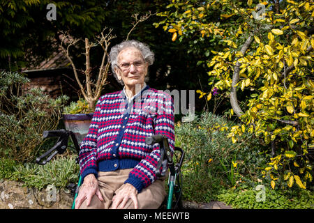 Femme âgée assise dans son jardin à West Sussex England Banque D'Images