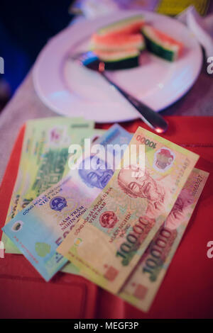 Le pourboire dans un restaurant au Vietnam Asie dongi, conseils d'argent sur la table pour le serveur Banque D'Images
