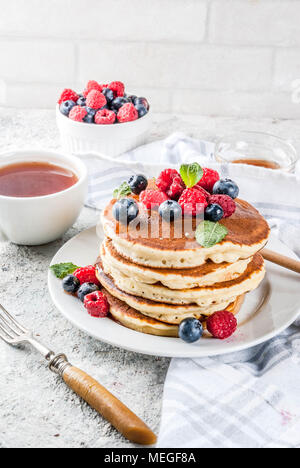 Petit-déjeuner d'été en bonne santé, des crêpes américaines classiques et aux petits fruits avec du miel, gris clair matin fond pierre copy space Banque D'Images