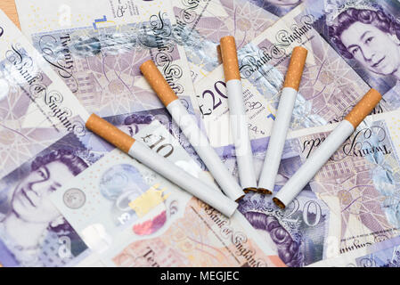 Concept de coût de fumer. Des cigarettes sur un arrière-plan billets Livre britannique Banque D'Images