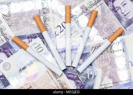 Concept de coût de fumer. Des cigarettes sur un arrière-plan billets Livre britannique Banque D'Images
