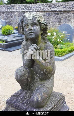 Un Chérubin en pierre statue dans le cimetière de l'église paroissiale, Berrien, Bretagne, France - John Gollop Banque D'Images