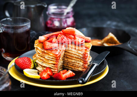 Pile de citron fraîchement préparé des crêpes aux graines de pavot avec des fraises fraîches et du sirop pour le petit déjeuner Banque D'Images