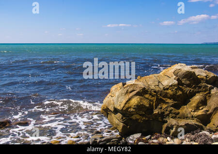 Rocky mer avec plage de galets, les vagues transparentes avec mousse, sur une chaude journée d'été Banque D'Images