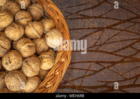 Les noix dans un bol en bois sur une table en bois avec des coquilles de noix Banque D'Images