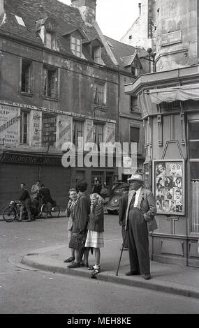 1936, historique, la mère avec les enfants manger glaces en attente de traverser la rue à l'angle de la rue Paul Doumer, dans le centre historique de Caen, Normandie, France. La ville était le fief de Guillaume le Conquérant mais a été gravement endommagé pendant la Seconde Guerre mondiale. Banque D'Images