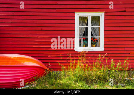 Maison en bois en norvégien Solvorn, la Norvège, la façade rouge d'un chalet typique avec petit bateau sur le mur extérieur Banque D'Images