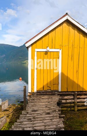 Maison de bateau jaune, de la Norvège, à la jetée le Sognefjorden, emplacement idyllique sur le fjord dans le village Solvorn, Lustrafjorden, comté de Sogn og Fjordane Banque D'Images