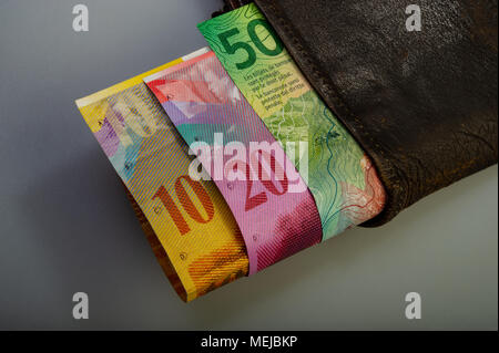 Trésorerie suisse confessions papier - dix, vingt, cinquante francs sont dans un vieux portefeuille. La bourse avec l'argent se trouve sur un fond clair. Banque D'Images